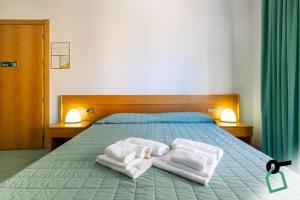 a bedroom with a bed with towels on it at Hotiday Alghero Spiaggia in Alghero