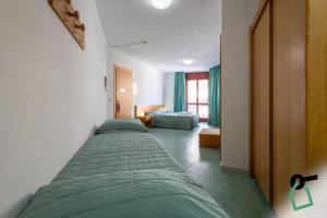 a hotel room with two beds and a room with a bedroom at Hotiday Alghero Spiaggia in Alghero