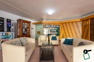 a living room with two white couches and a table at Hotiday Alghero Spiaggia in Alghero