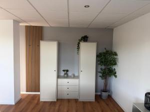 a room with two tall white doors and a cabinet at Truck Inn in Bünde