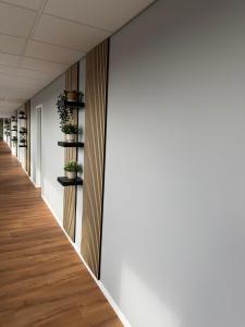 a corridor of an office building with plants on shelves at Truck Inn in Bünde
