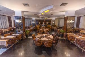 a restaurant with tables and chairs in a room at Dilshad Palace Hotel in Duhok