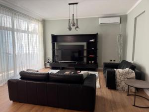 a living room with a black couch and a fireplace at Maya's home Tirana in Tirana
