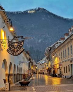 a street in a town with a mountain in the background at Baritiu Apartment Brasov in Braşov