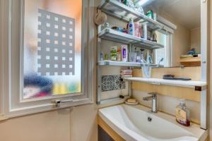 a bathroom with a sink and a window at Location Mobilhome Agde in Agde +17 photos