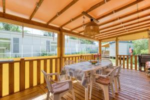 a dining room with a table and chairs on a deck at Location Mobilhome Agde in Agde