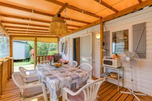 a dining room with a table and chairs on a deck at Location Mobilhome Agde in Agde