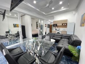 a living room with a glass table and leather chairs at PATONG TOWER Residence Apartments 2026 in Patong Beach