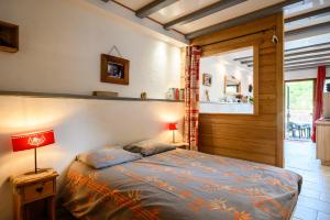 a bedroom with a bed and two lamps on a table at Gîte La Petite Maison Des Vacances in Kaysersberg