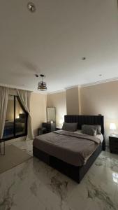 a bedroom with a large bed in a room at نسمة الخبر كورنيش اقامة رائعة وهادئة in Dammam