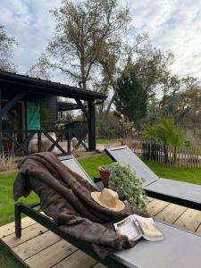 a picnic table with a blanket and a hat on it at Le Chalet du lac in Biscarrosse