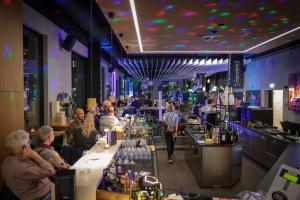 a group of people sitting at a bar at AVES Hotel&Apartment Arosa in Arosa