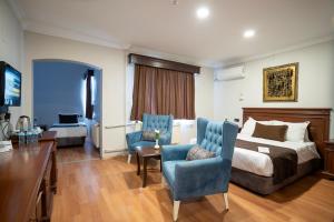a hotel room with a bed and a desk and chairs at Buyuk Velic Hotel in Gaziantep