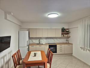 a kitchen with a table and a white refrigerator at Apartman Bruna in Novigrad Istria