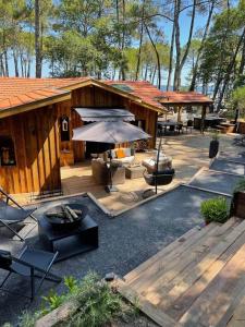 an outdoor patio with a table and an umbrella at Le Chalet Maguide in Biscarrosse