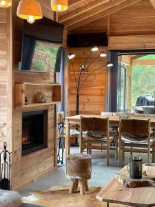 a living room with a table and a fireplace at Le Chalet Maguide in Biscarrosse