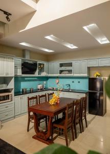 a kitchen with a wooden table and a black refrigerator at Doris Entire House Da Nang in Danang +18 photos