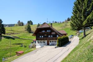a large wooden house on a hill with a road at Ferienwohnung Haus Eckhof in Wieden