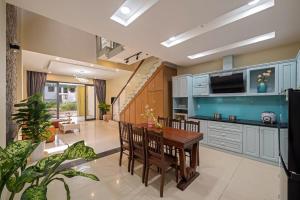 a kitchen with blue cabinets and a table and chairs at Doris Entire House Da Nang in Danang