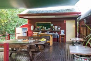 a patio with a table and chairs on a deck at Glasshouse Mountains Ecolodge in Glass House Mountains