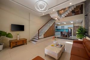 a living room with a couch and a staircase at Doris Entire House Da Nang in Danang