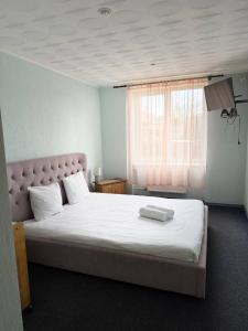 ein Schlafzimmer mit einem großen weißen Bett und einer weißen Matratzenauflage in der Unterkunft Olimpija Hotel & SPA in Daugavpils