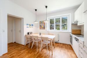 a kitchen and dining room with a table and chairs at Alpine Zeitgeist Apartment - by myNests in Gröbming