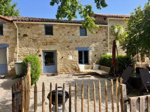 a stone house with a fence in front of it at Le Plantier2 in Beaulieu-sur-Sonnette