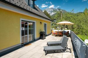 a patio with a table and chairs and an umbrella at Alpine Zeitgeist Apartment - by myNests in Gröbming