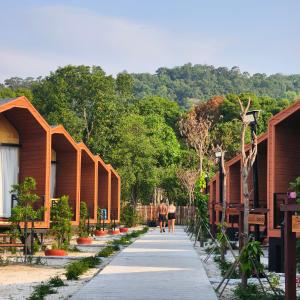 two people walking down a walkway between houses at Royal C Beach Resort in Koh Rong Island