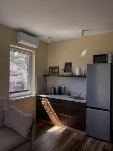 a kitchen with a white refrigerator and a sink at 4 winds Notus in Palanga