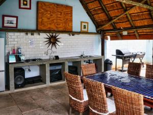 a dining room with a table and chairs and a grill at Apartments @ 125 in Gaborone