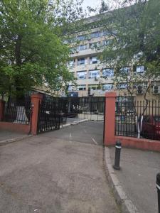 a black fence with a parking lot in front of a building at Hotel viilor in Bucharest