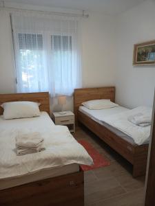 a bedroom with two beds and a window at APARTMAN Verica 2025 in Vrdnik
