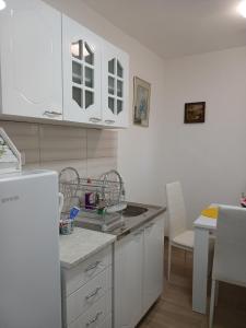 a kitchen with white cabinets and a white refrigerator at APARTMAN Verica 2025 in Vrdnik