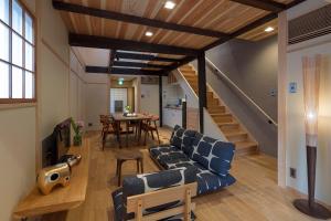 Una sala de estar con un sofá azul y una mesa. en Shimabara Kaiden Machiya House, en Kioto