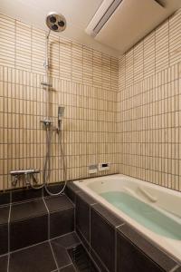un baño con bañera y ducha en Shimabara Kaiden Machiya House, en Kioto 25 fotos más
