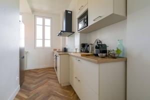 a kitchen with white cabinets and a counter top at Le Victor Hugo in Dijon
