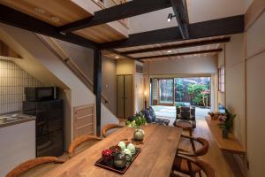 Una cocina y un comedor con mesa y sillas de madera. en Shimabara Kaiden Machiya House, en Kioto