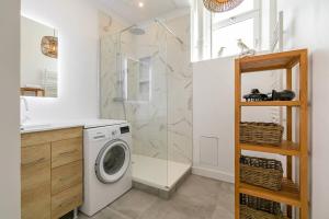 a bathroom with a washing machine and a shower at Le Victor Hugo in Dijon