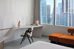 a bedroom with a desk and a chair and window at Kimpton KAFD Riyadh by IHG in Riyadh