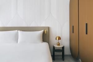 a bedroom with a bed and a side table at Kimpton KAFD Riyadh by IHG in Riyadh