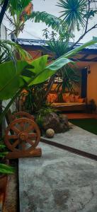 a wooden bench in a garden with palm trees at GRG Stays-MatteoS in Santo Domingo