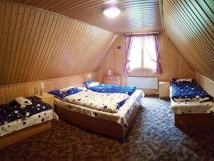 a bedroom with three beds and a window at Chalupka pod Kozincom - Zázrivá in Zázrivá