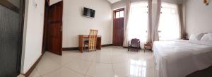 a bedroom with a bed and a table and a window at Kilimanjaro Magic in Moshi