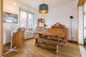 a living room with a wooden table and a fan at La Montrachet in Dijon +10 photos