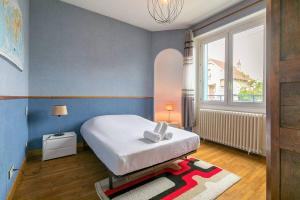 a bedroom with a bed and a large window at La Montrachet in Dijon