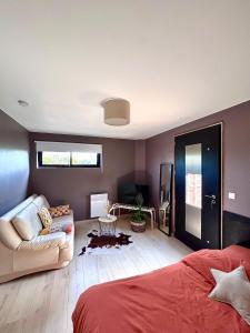a living room with a bed and a couch at Le kesson in Saint-Brieuc