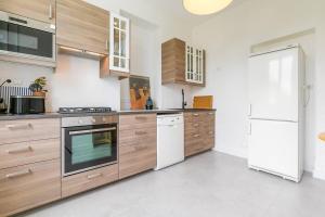 a kitchen with wooden cabinets and a white refrigerator at La Montrachet in Dijon