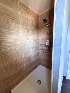 a bathroom with a shower with a wooden wall at Le kesson in Saint-Brieuc +6 photos